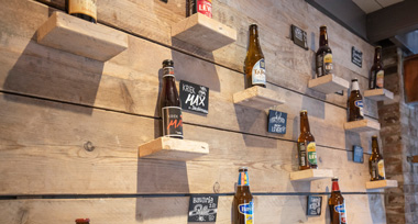 Bierflesjes aan de muur bij Fletcher Hotel-Restaurant De Klepperman
